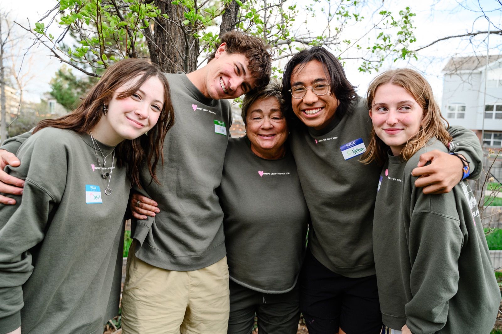 Four teens with their arms around each other, laughing