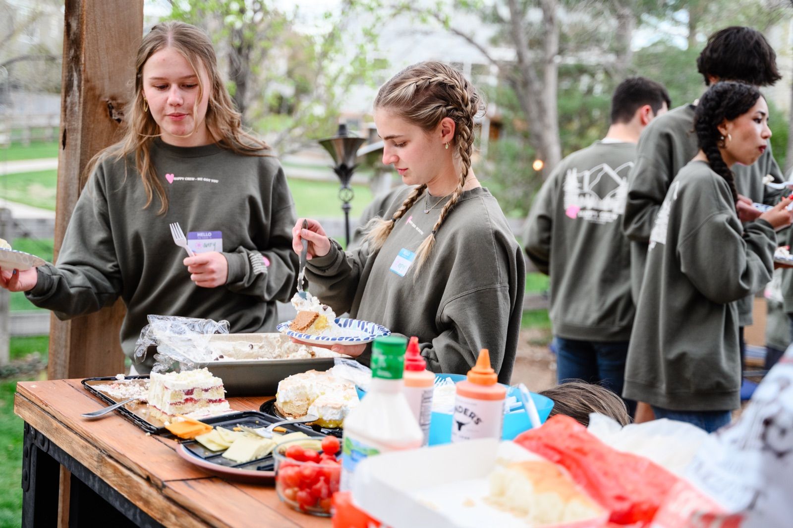 Teens serving themselves dinner at a long table