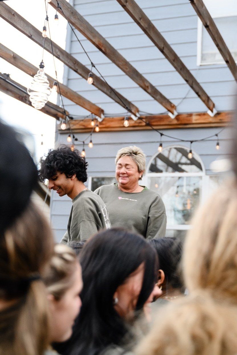 Amy laughing with a student leader under the pergola, other teens around them