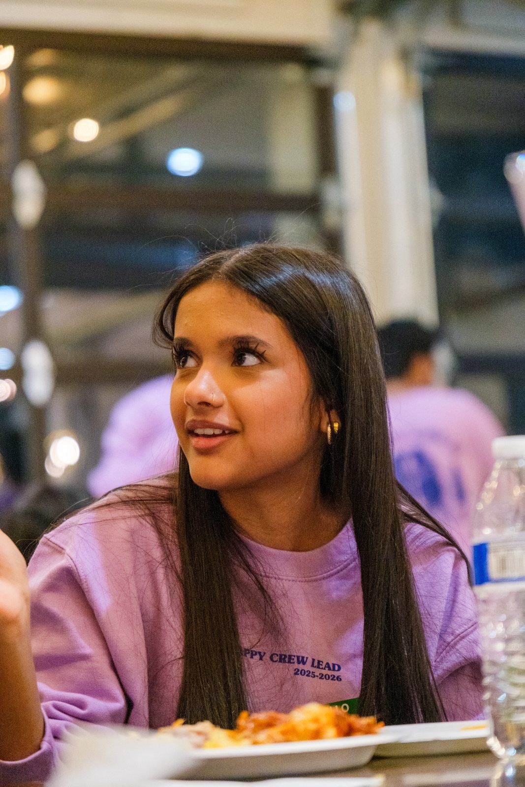 A student leader at dinner, looking across the table