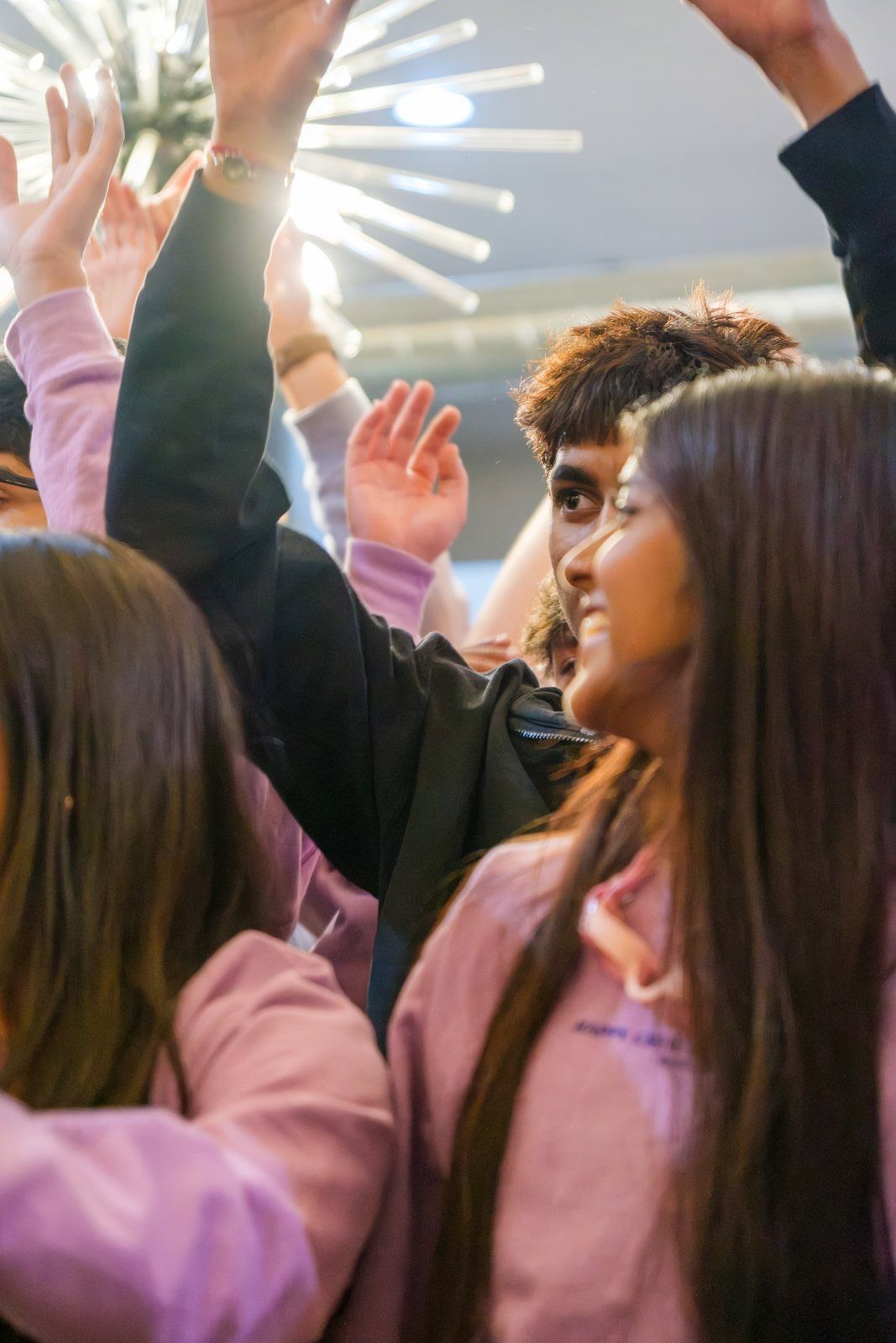 Teens cheering, hands up under the starburst light