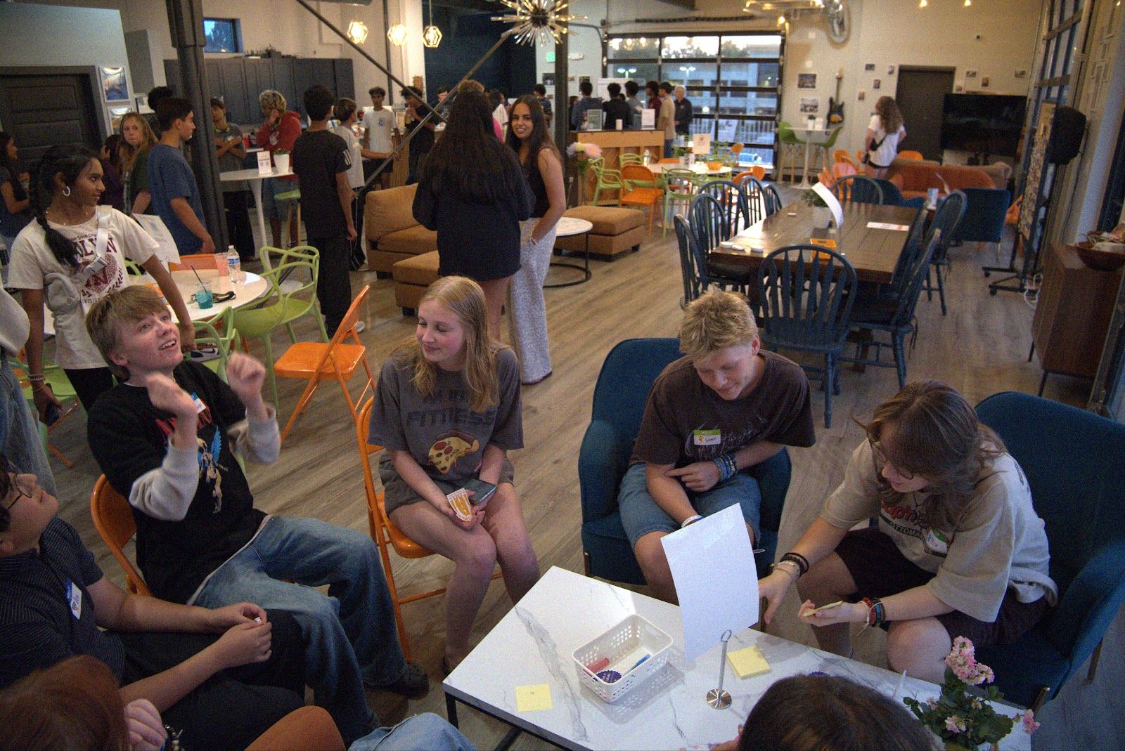 Teens in a circle of chairs working on something together