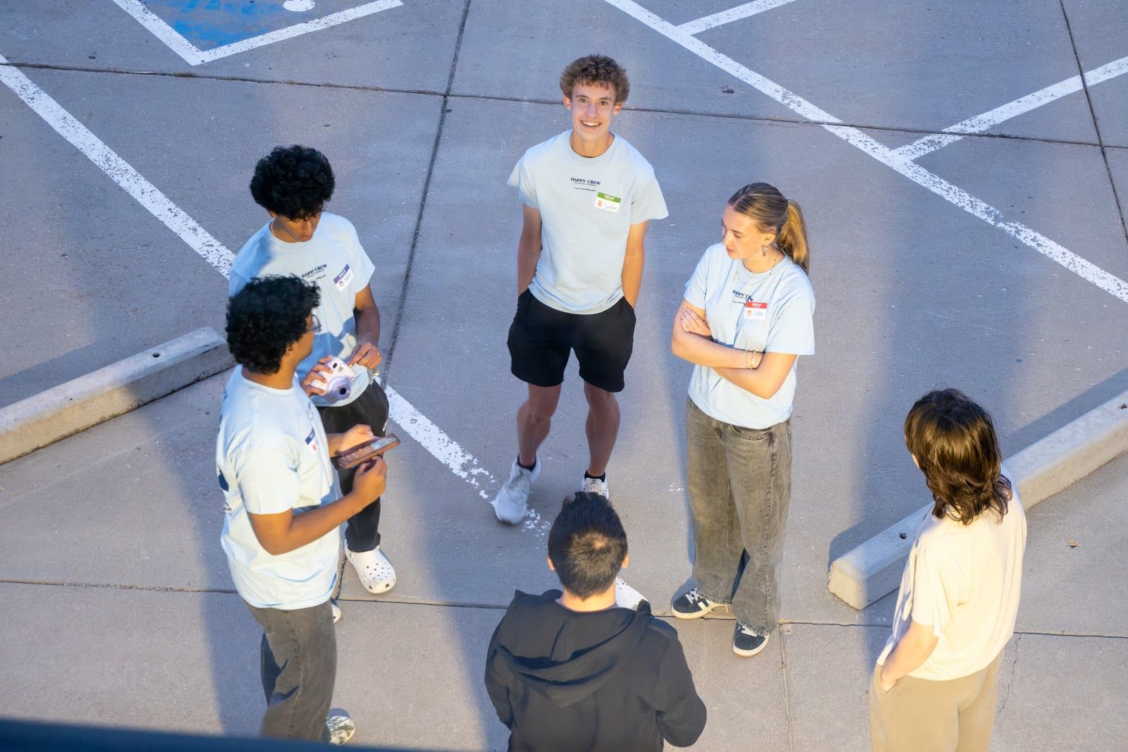 Teens in the parking lot at night, seen from above