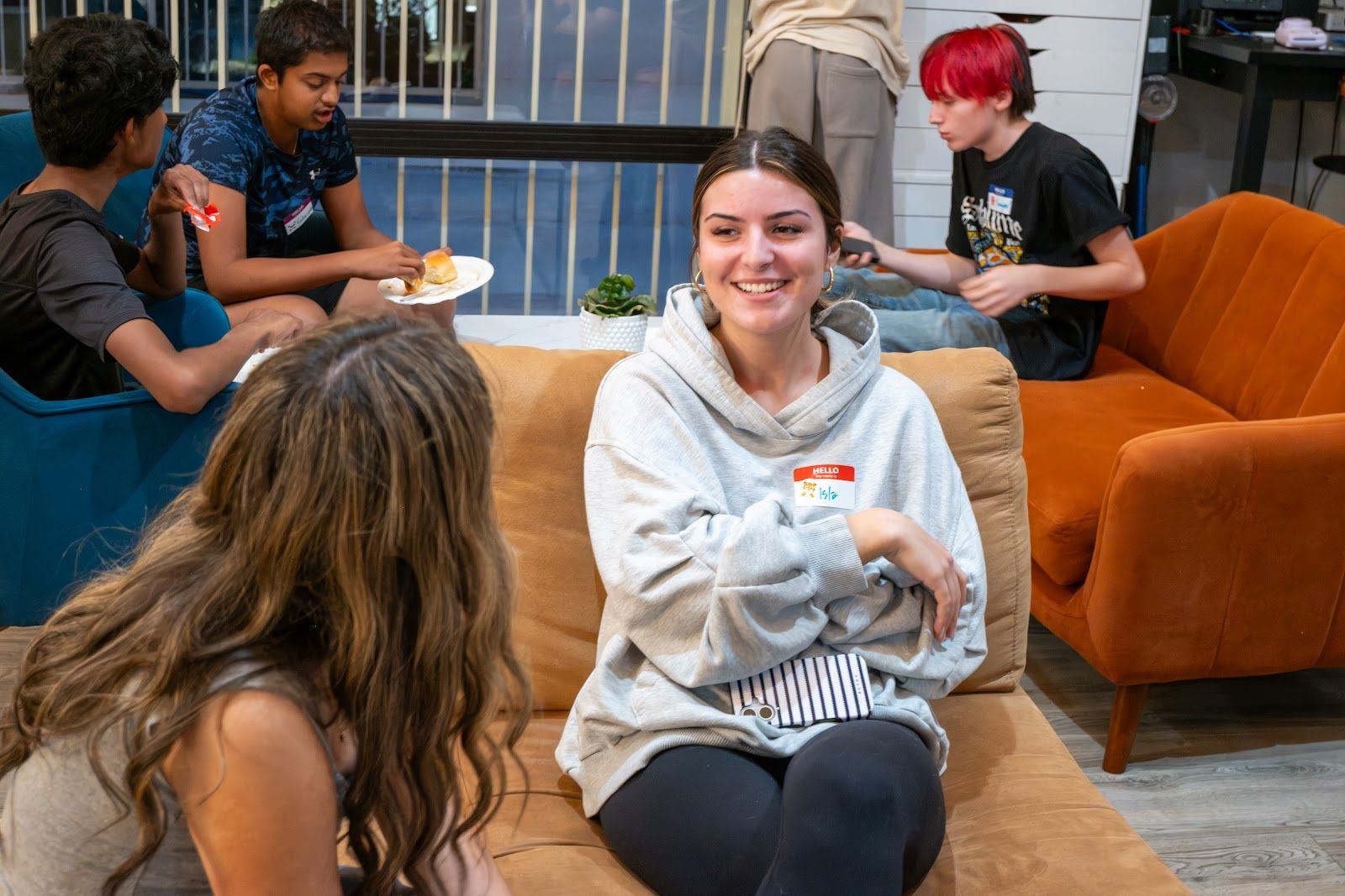 A teen laughing on the orange couch