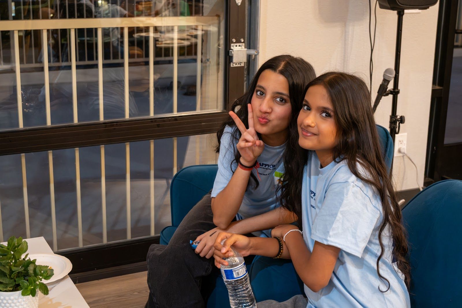 Two friends smiling on a couch at Happy Crew